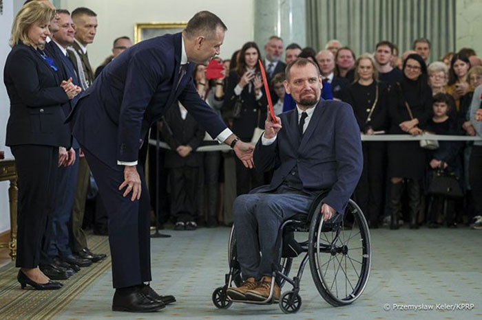 Zdjęcie z wręczenia nominacji profesorskiej prof. Maciejowi Sydorowi. Na zdjęciu z lewej strony Prezydent RP z prawej prof. Maciej Sydorowicz. W tle uczestnicy uroczystości.