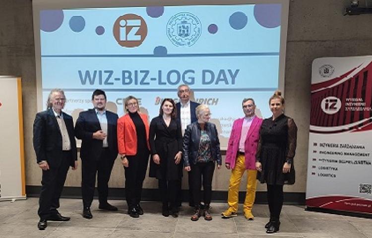 Zdjęcie uczestników na tle plakatu wiz-biz-log day