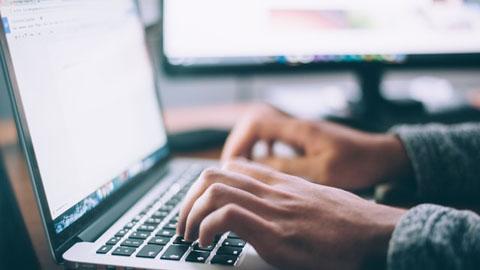 Zdjęcie rąk osoby pracującej przy laptopie