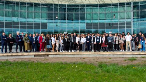 Zdjęcie grupowe uczestników Konferencji 11 Forum Logistyczne przed budynkiem Centrum Wykładowego Politechniki Poznańskiej